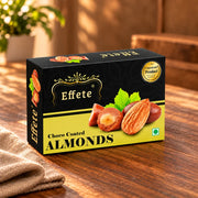A black and yellow box of chocolate-coated almonds is displayed on a wooden surface.