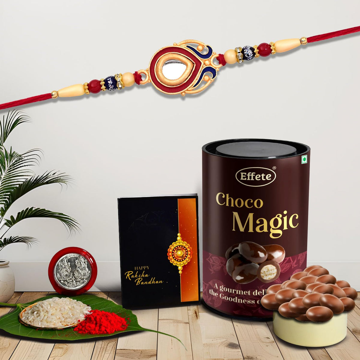 Rakhi set for brother with chocolate and traditional accessories on white background