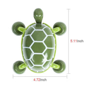 An overhead view of the green turtle massage tool displays its dimensions, with a white patterned shell.