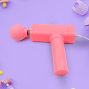 Portable massage gun being charged via a USB cable