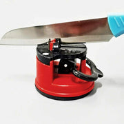 A knife with a light blue handle is being sharpened in the red and black device.