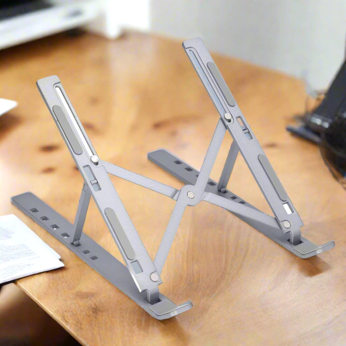 Folded metal laptop stand, highlighting its compact portability