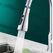 A close-up of a chrome faucet sprayer head dispensing a strong, aerated stream of water into a sink.