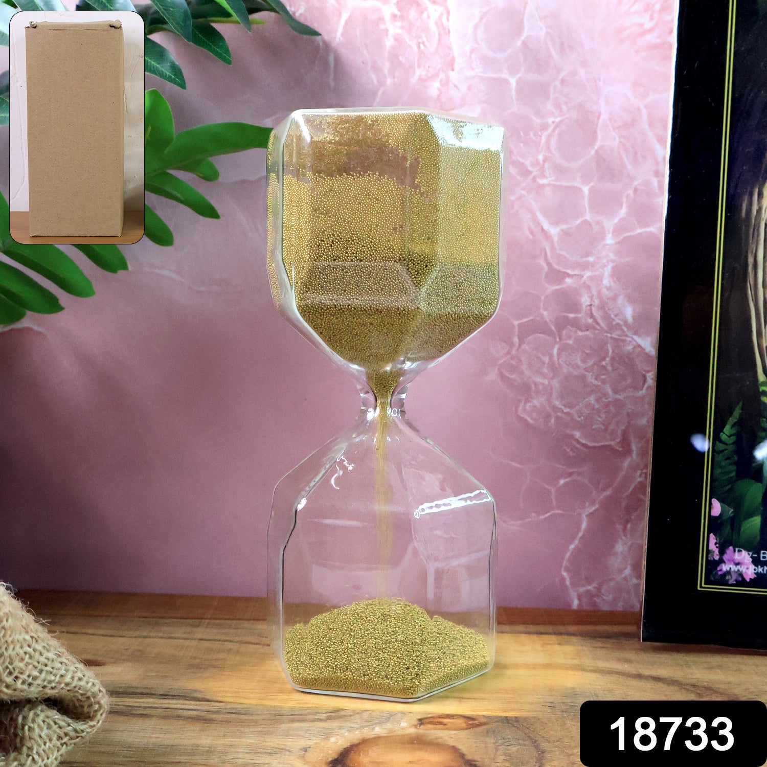 Faceted glass hourglass with golden sand on white background