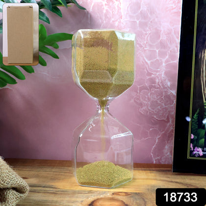 Faceted glass hourglass with golden sand on white background