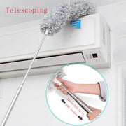 A duster with an extended handle cleaning the top of a white air conditioning unit, with an inset showing hands