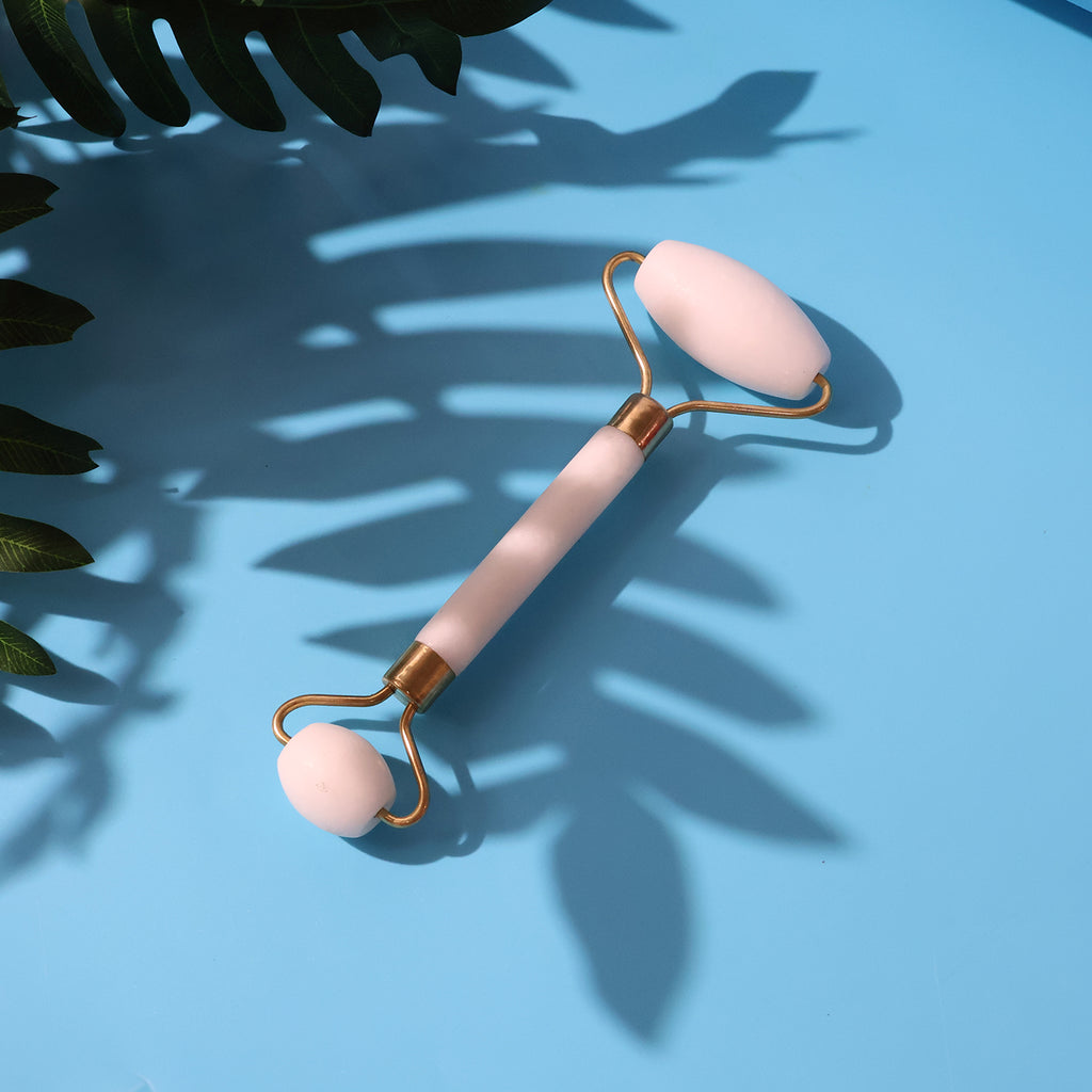 Hand holding dual-ended face massage roller
