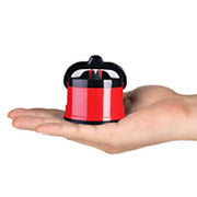 A small red and black knife sharpener rests in the palm of a hand, showing its compact size.