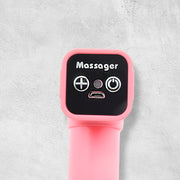 Woman using a handheld massage gun on her back for muscle recovery