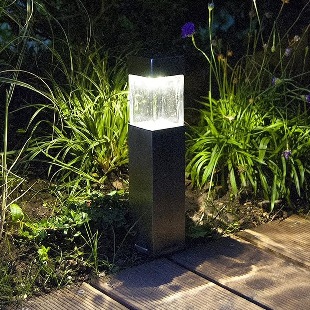 Solar-powered pathway light installed in a garden