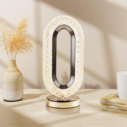 LED crystal table lamp glowing with warm light on a bedside table