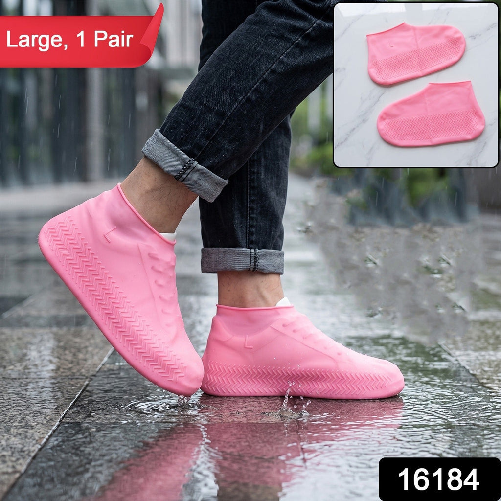 A person wears pink silicone shoe covers on a wet sidewalk; a red banner says "Large, 1 Pair" and a black box has "16184".