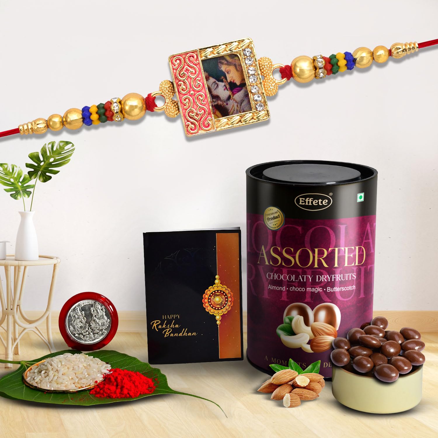Rakhi set with silver color pooja coin, greeting card, roli-chawal pack, and chocolate