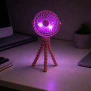 Mini rechargeable fan with flexible legs on a bedside table
