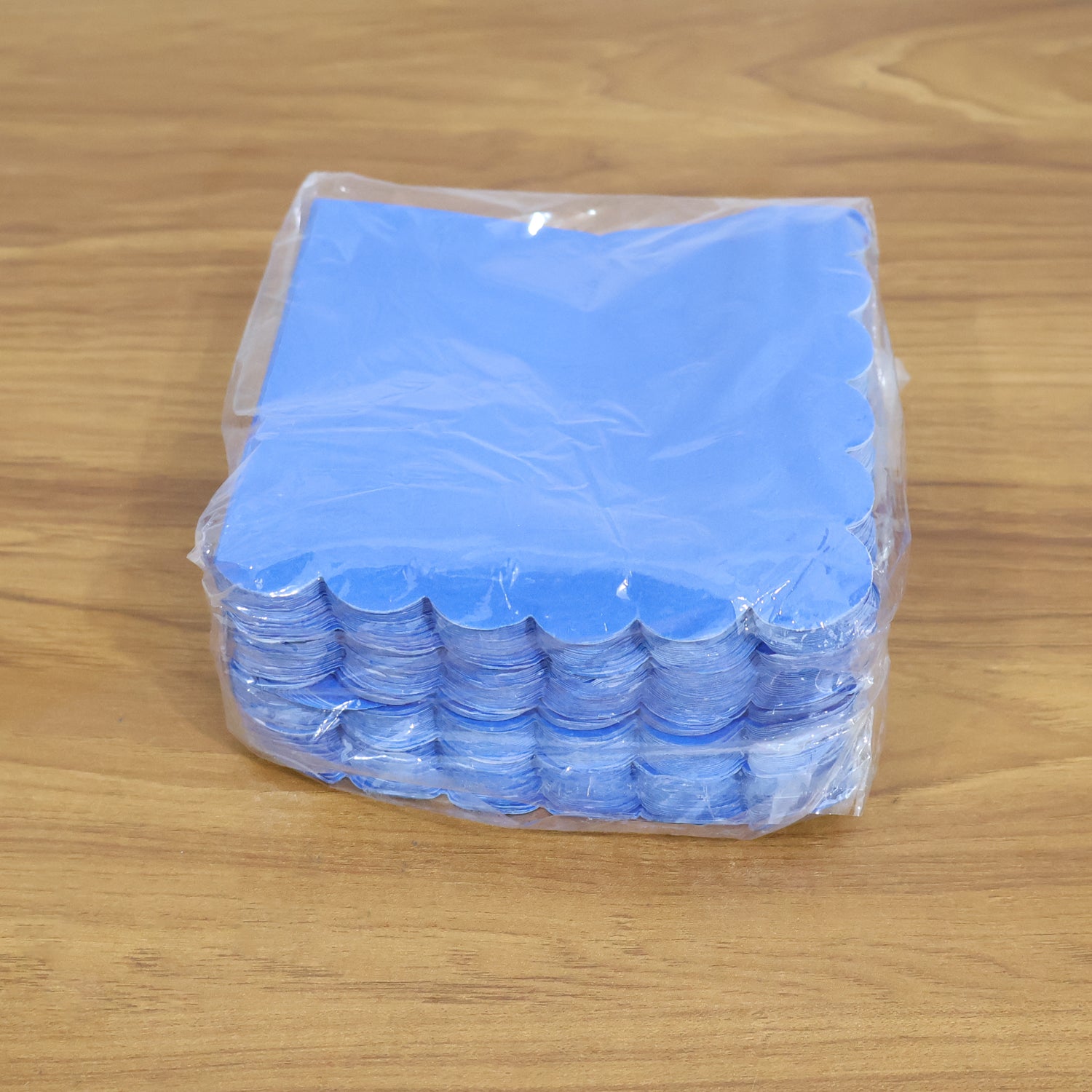 Royal blue scalloped napkins arranged with drinks & snacks for a party