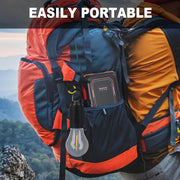 A black and clear light bulb hangs from the side pocket of a large orange and blue backpack.