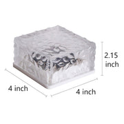 A clear, unlit square solar light with textured glass displays its dimensions of 4x4x2.15 inches.