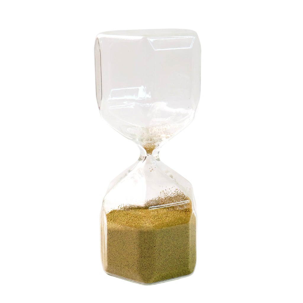 Faceted glass hourglass on desk for office décor and focus