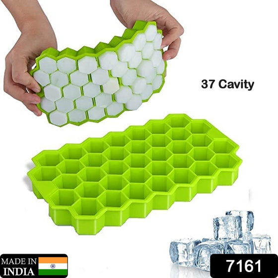 Two hands gently flex a green silicone honeycomb ice cube tray, releasing white hexagonal ice cubes. Another empty tray