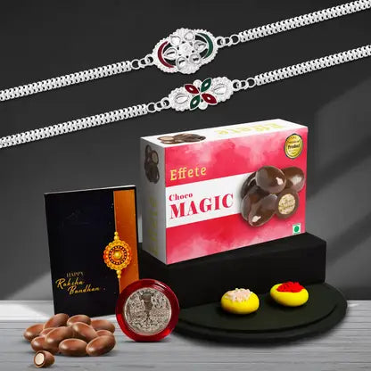 A vibrant Rakhi Gift Combo featuring two elegant Rakhis, a Choco Magic box, and a silver coin.