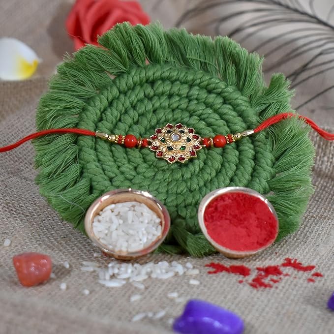 Traditional Rakhi tilak set with kumkum, chawal, and an auspicious silver pooja coin.