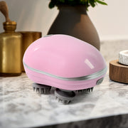 Handheld scalp massager showing ergonomic grip and USB charging port
