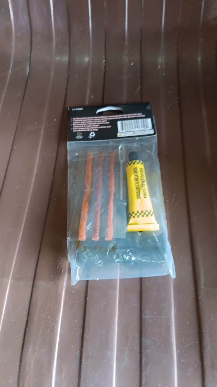 Tyre puncture repair kit displayed upright with tools