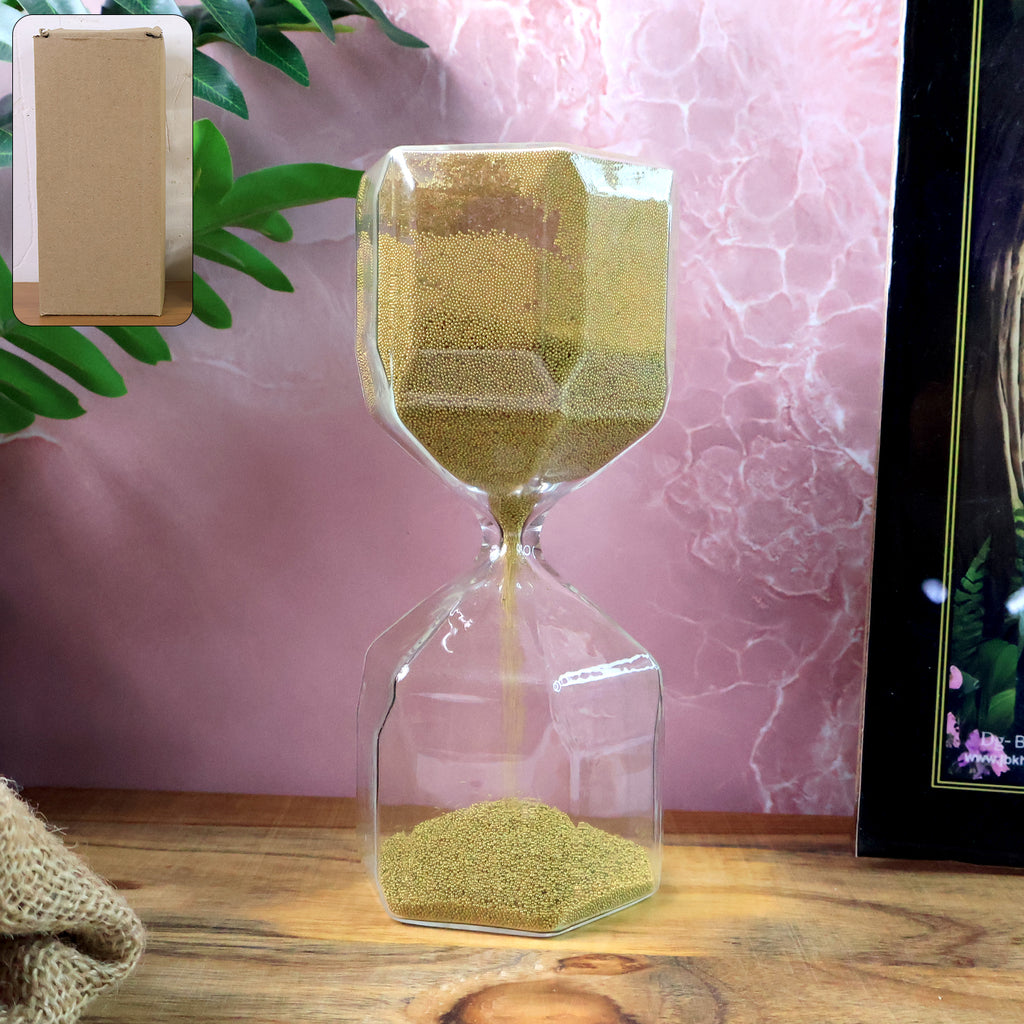 Close-up of golden sand flowing in faceted glass hourglass timer
