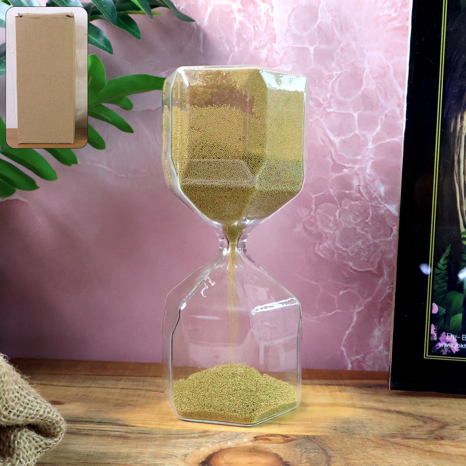 Close-up of golden sand flowing in faceted glass hourglass timer