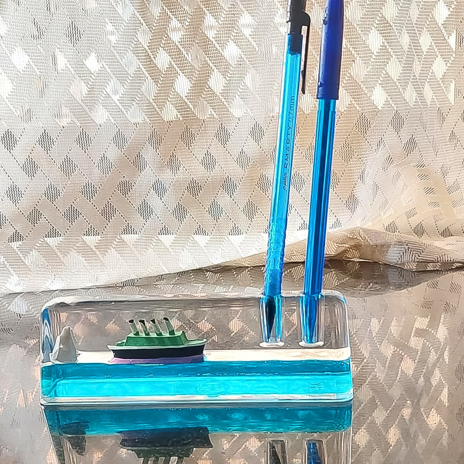 Stress-relief desk ornament with blue liquid & miniature ship scene