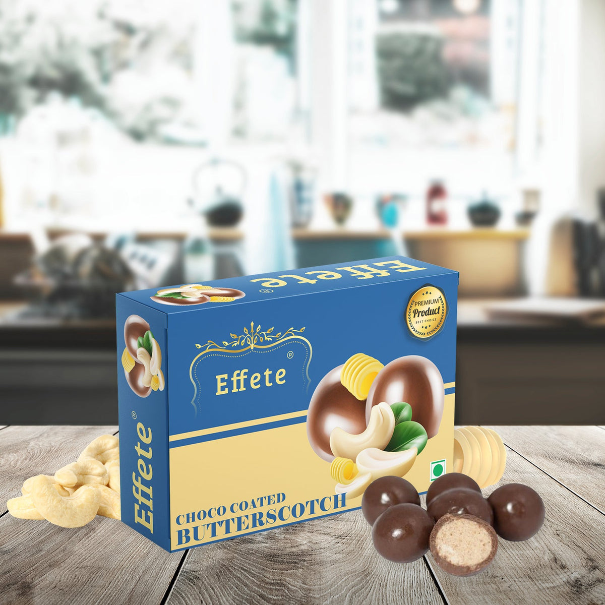 Blue and beige box of Effete Choco Coated Butterscotch candy with loose cashews and chocolates. One chocolate is cut open.