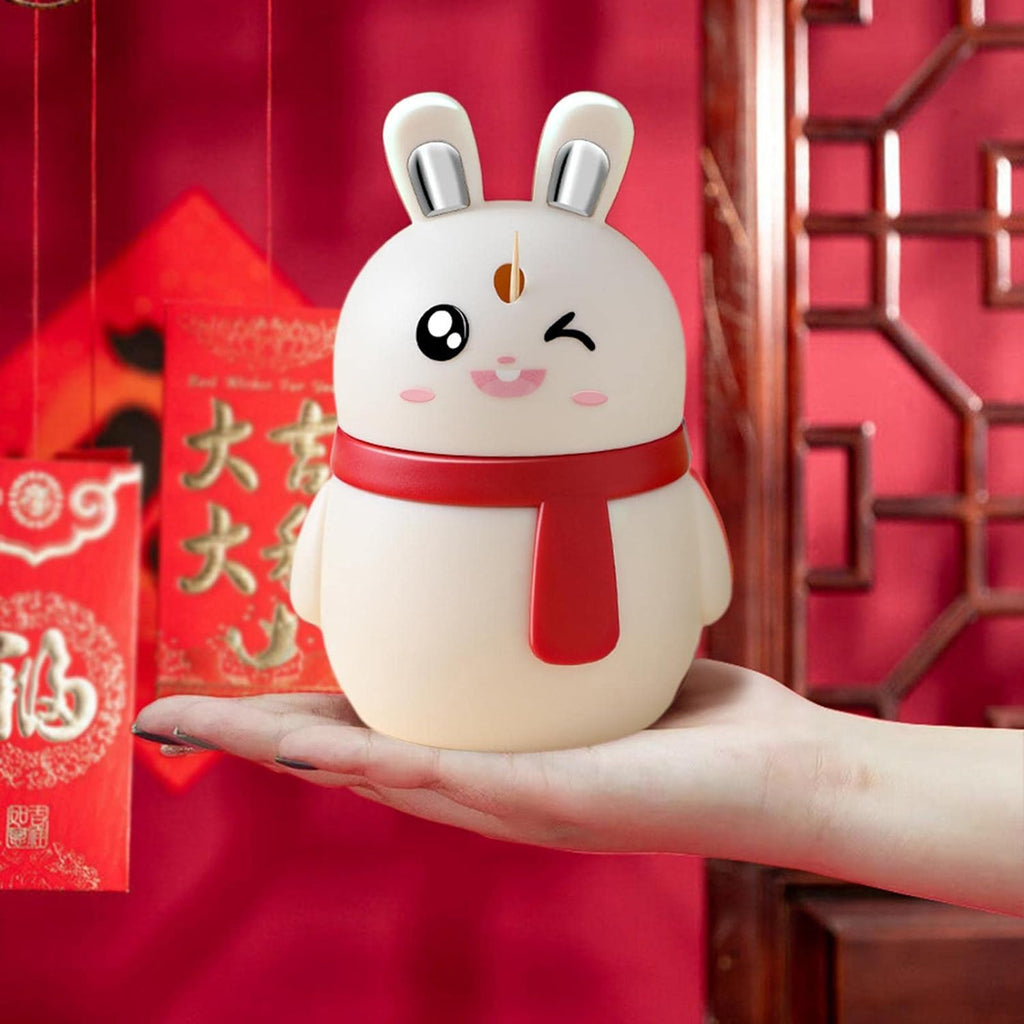 A hand demonstrating the press-out function of the rabbit toothpick dispenser.